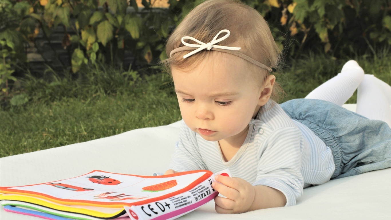 Маленькая девочка с книгой на природе