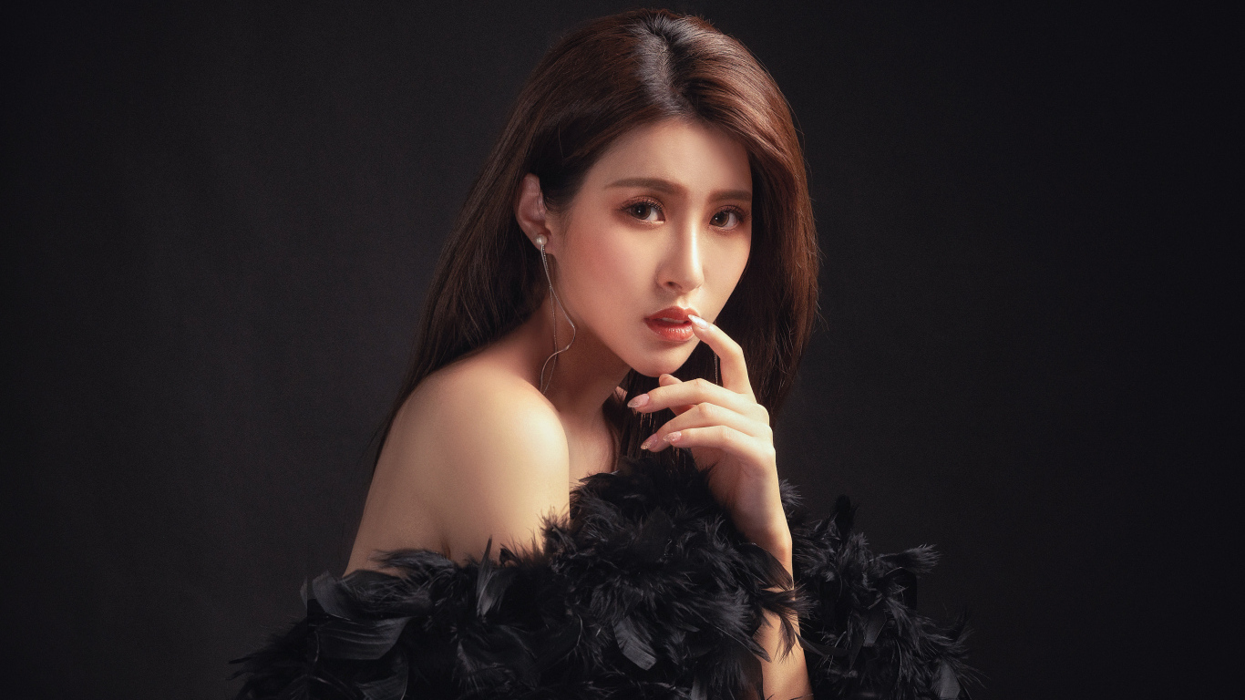 Девушка азиатка в боа на черном фоне