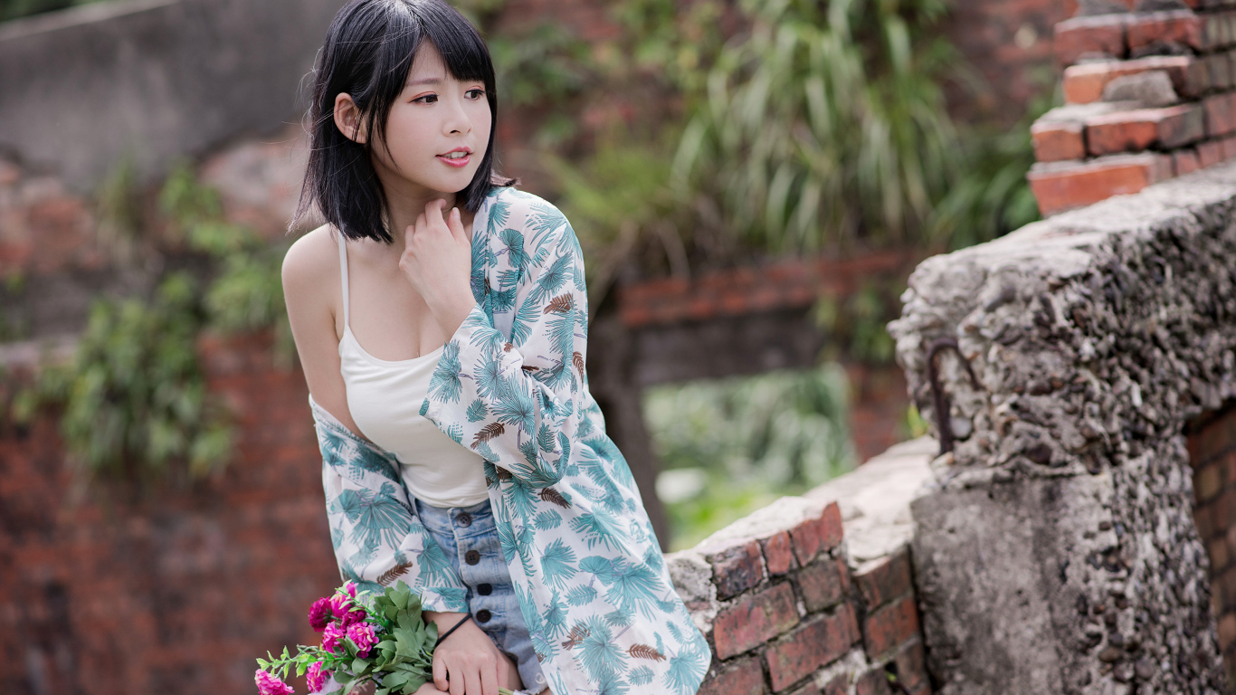 Красивая азиатка с цветком в руке