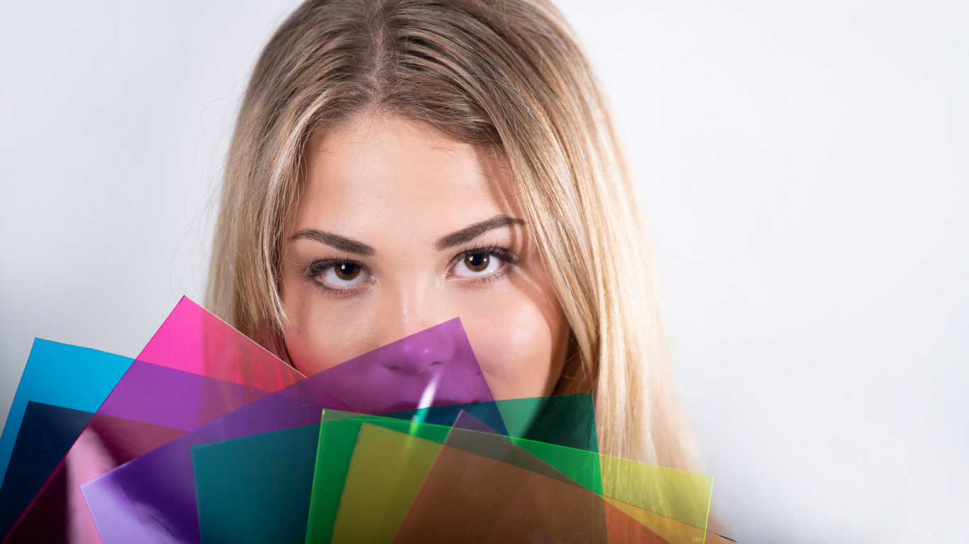 Красивая кареглазая девушка с разноцветной бумагой