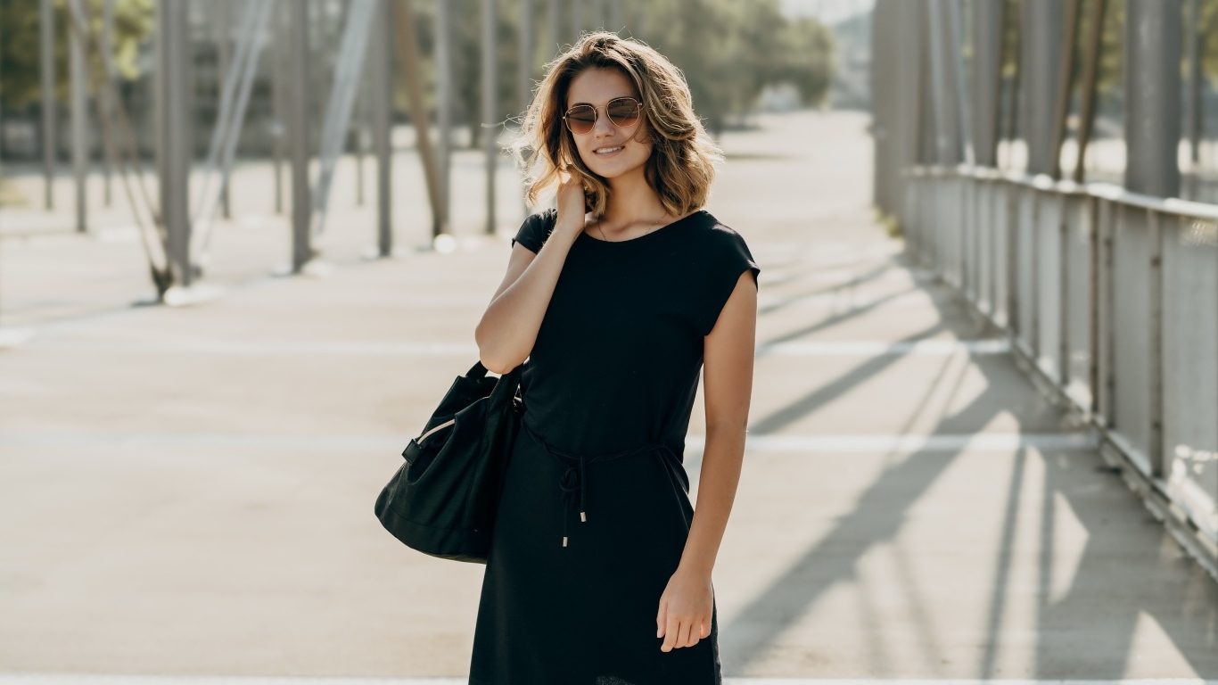 Красивая девушка в черном платье в очках