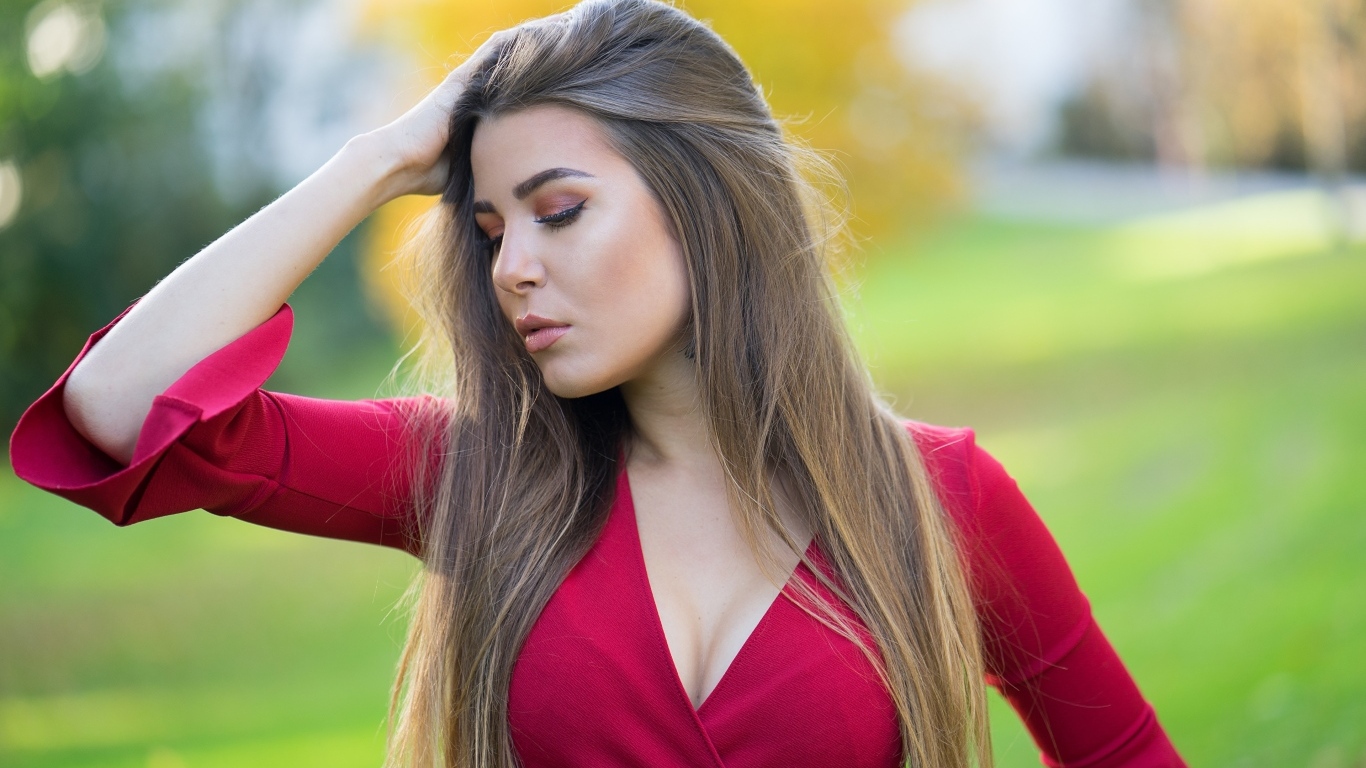 Красивая девушка в красном платье с рукой в волосах