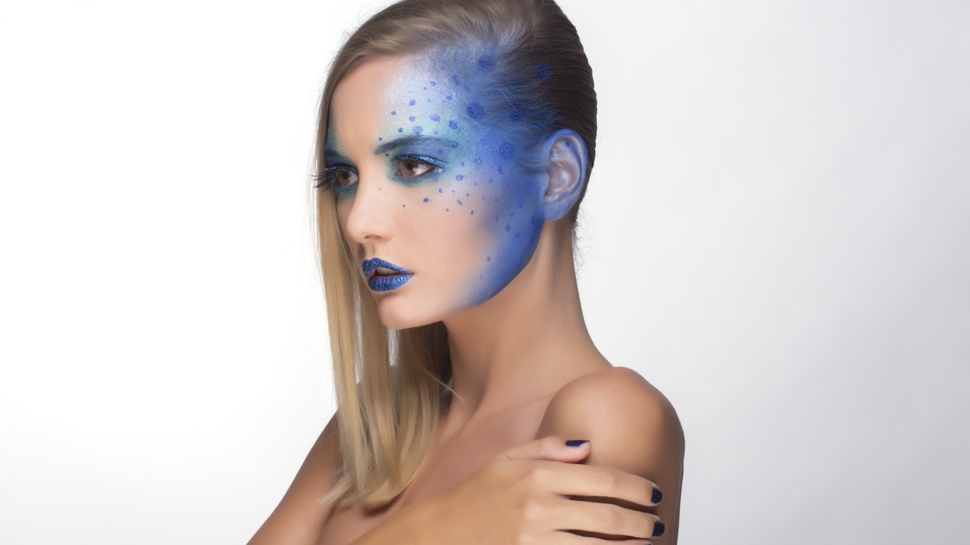 Красивая девушка с синим рисунком на лице