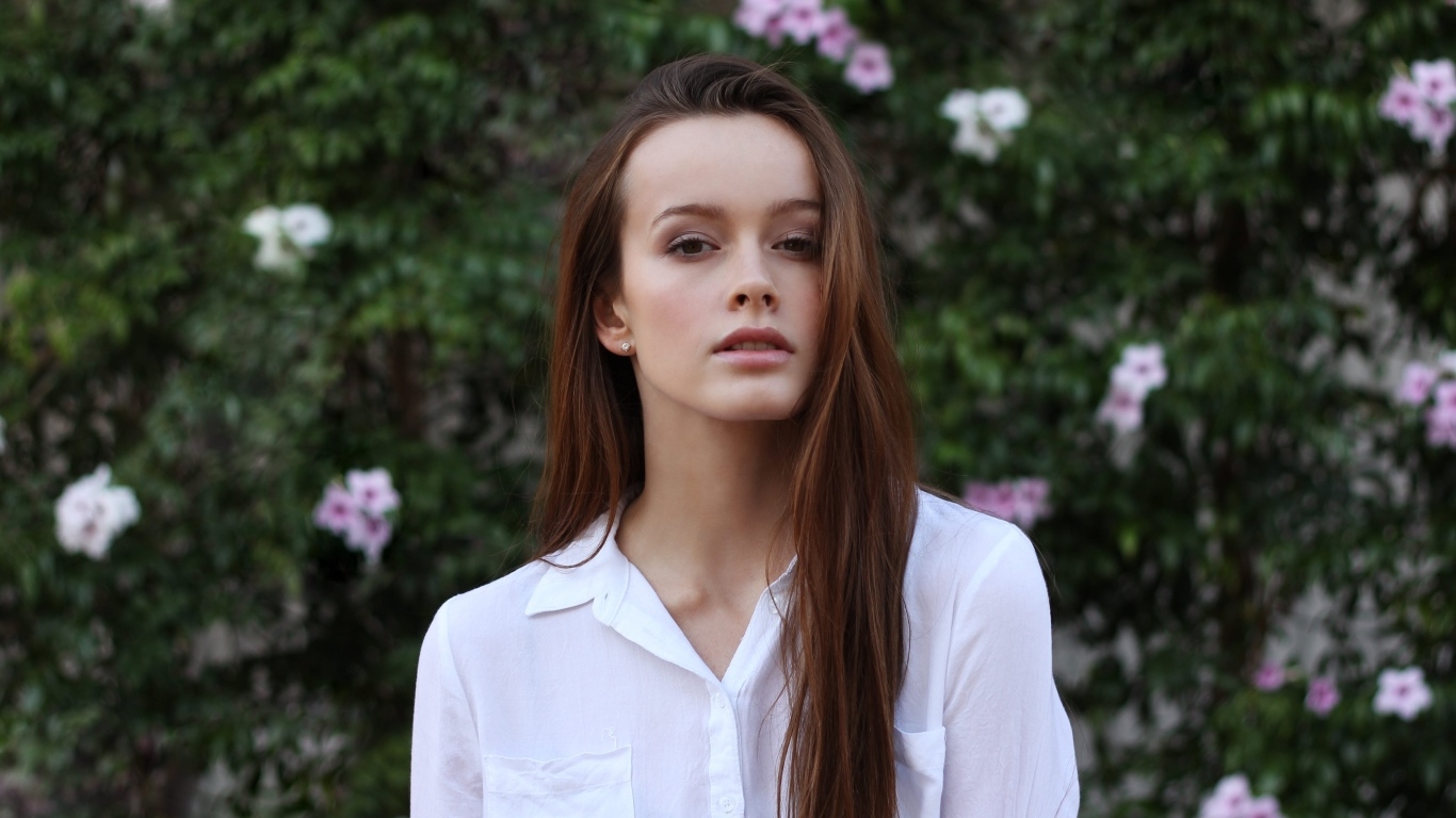 Красивая длинноволосая девушка в белой рубашке