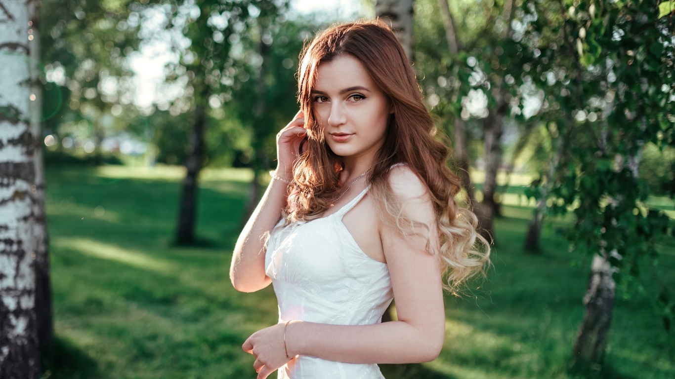 Красивая длинноволосая девушка в парке