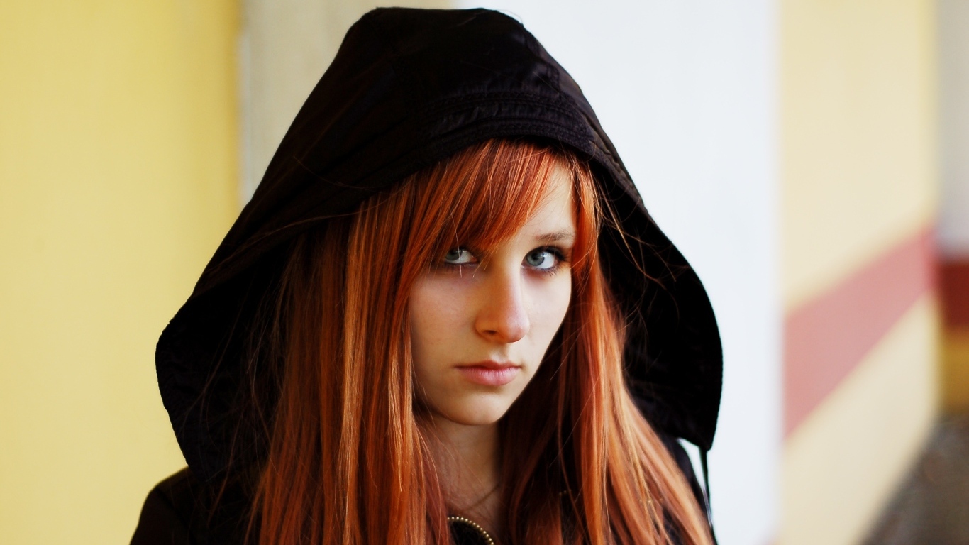 Красивая рыжеволосая девушка в черном балахоне