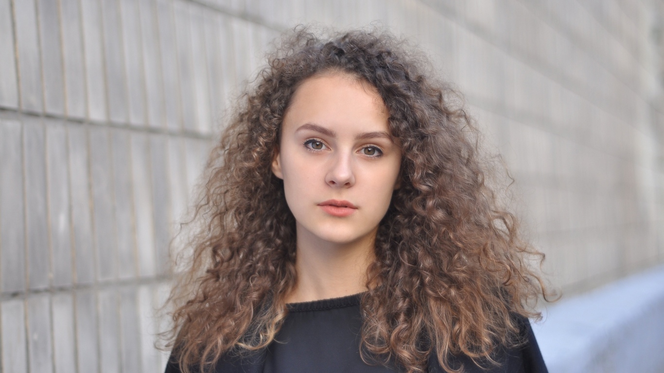 Кудрявые волосы красивой кареглазой девушки 
