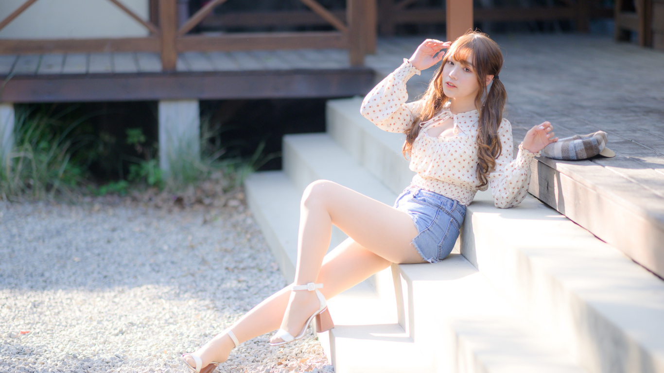 Милая настоящая азиатка сидит на ступеньках