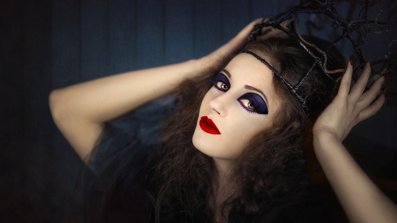 Девушка в черном наряде с ярким макияжем