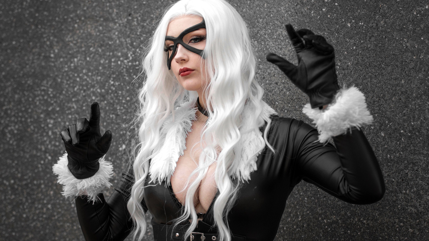 Девушка в белом парике в черном костюме у серой стены