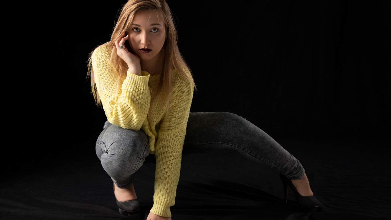 Девушка в желтом свитере на черном фоне