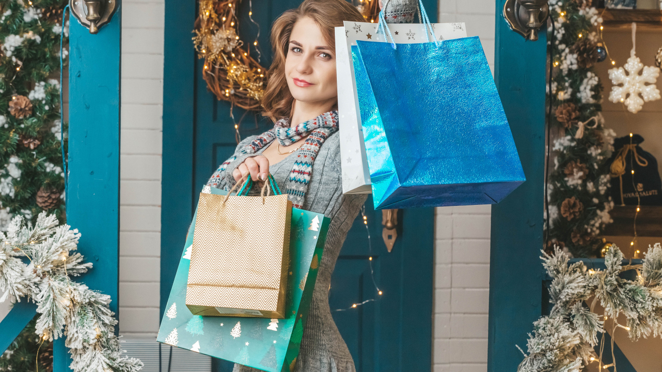 Девушка с пакетами стоит у двери