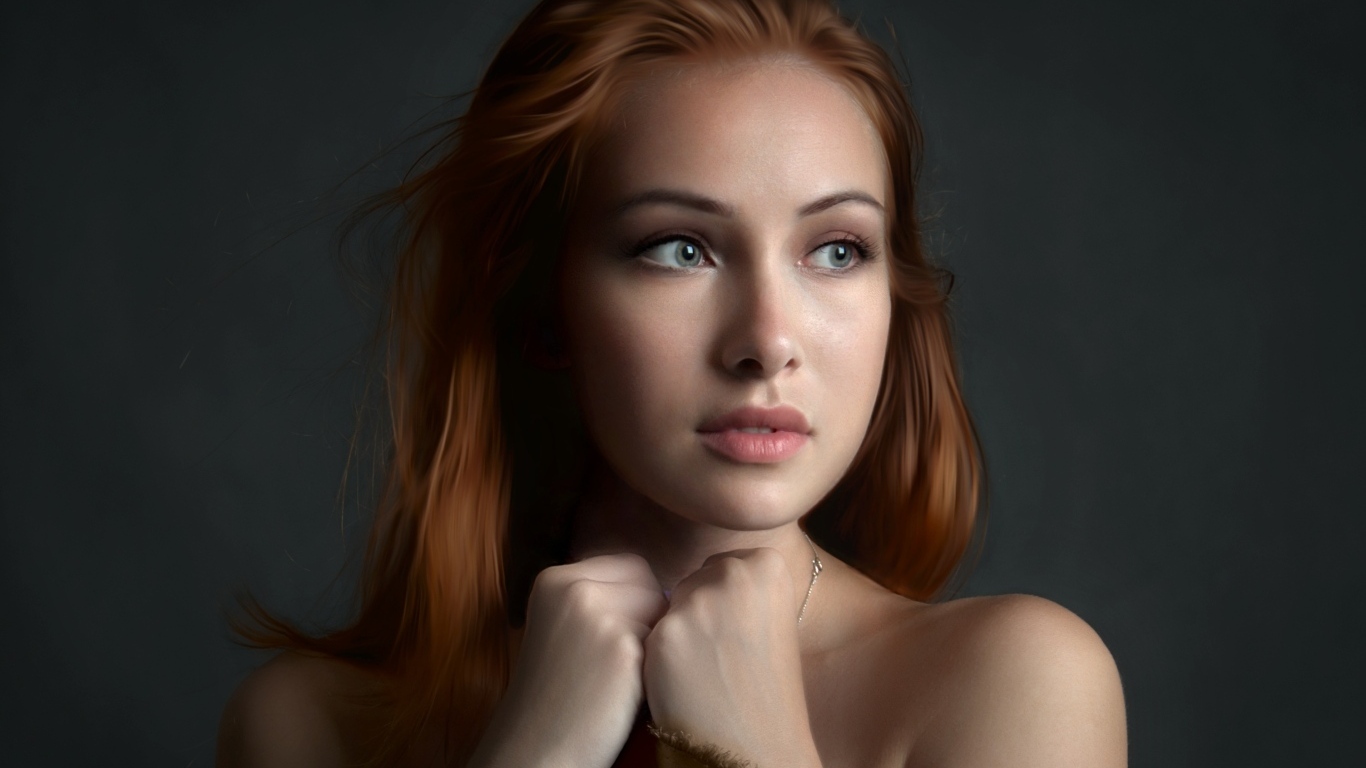 Рыжеволосая девушка с красивыми серыми глазами на сером фоне