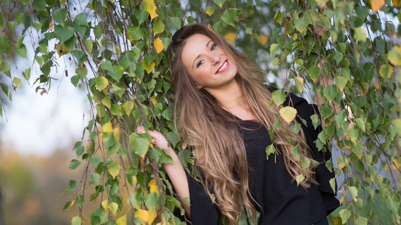Улыбающаяся девушка в ветках березы