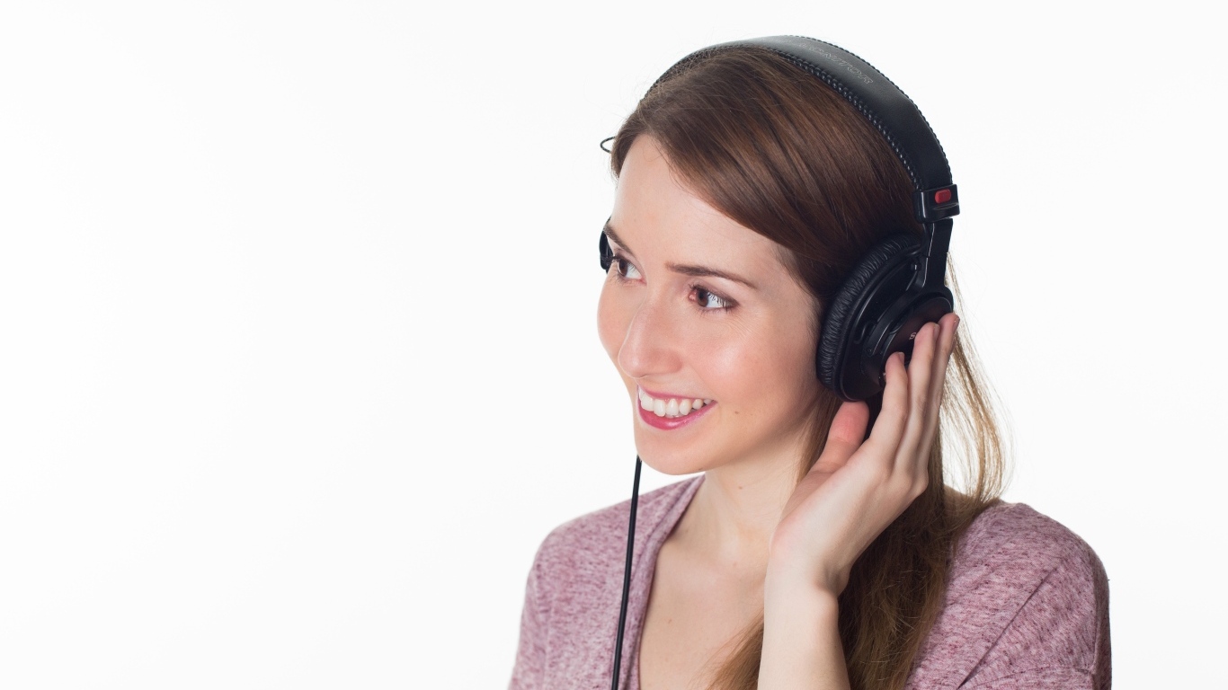 Улыбающаяся девушка в черных наушниках