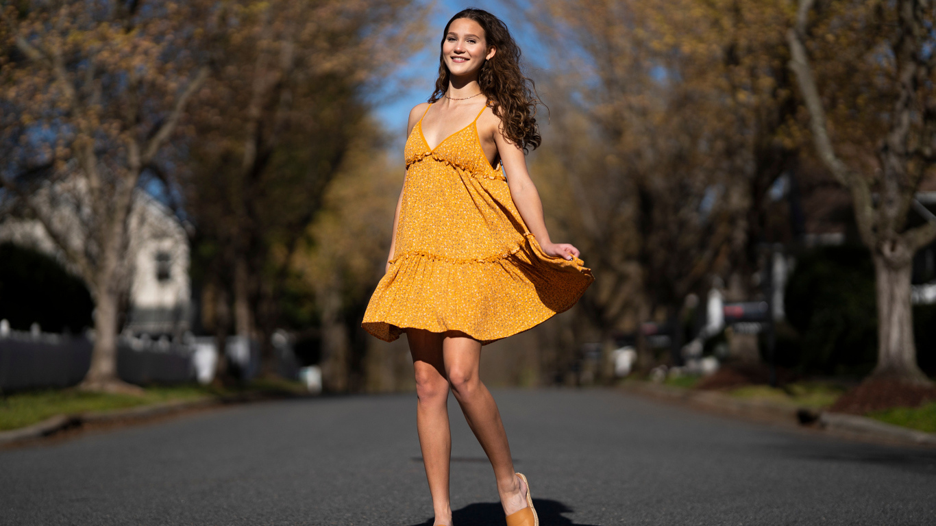 Молодая девушка в коротком платье на дороге  летом