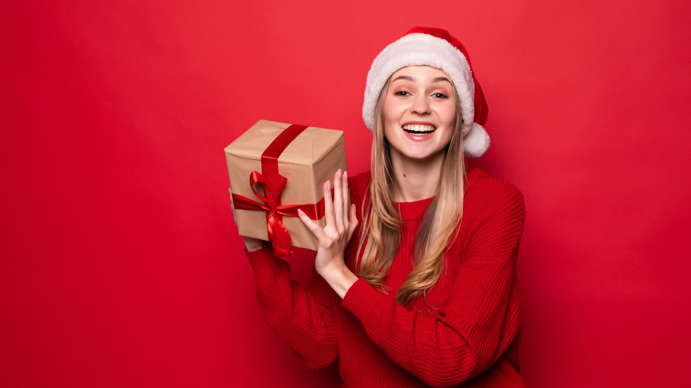 Улыбающаяся девушка с подарком в новогоднем костюме