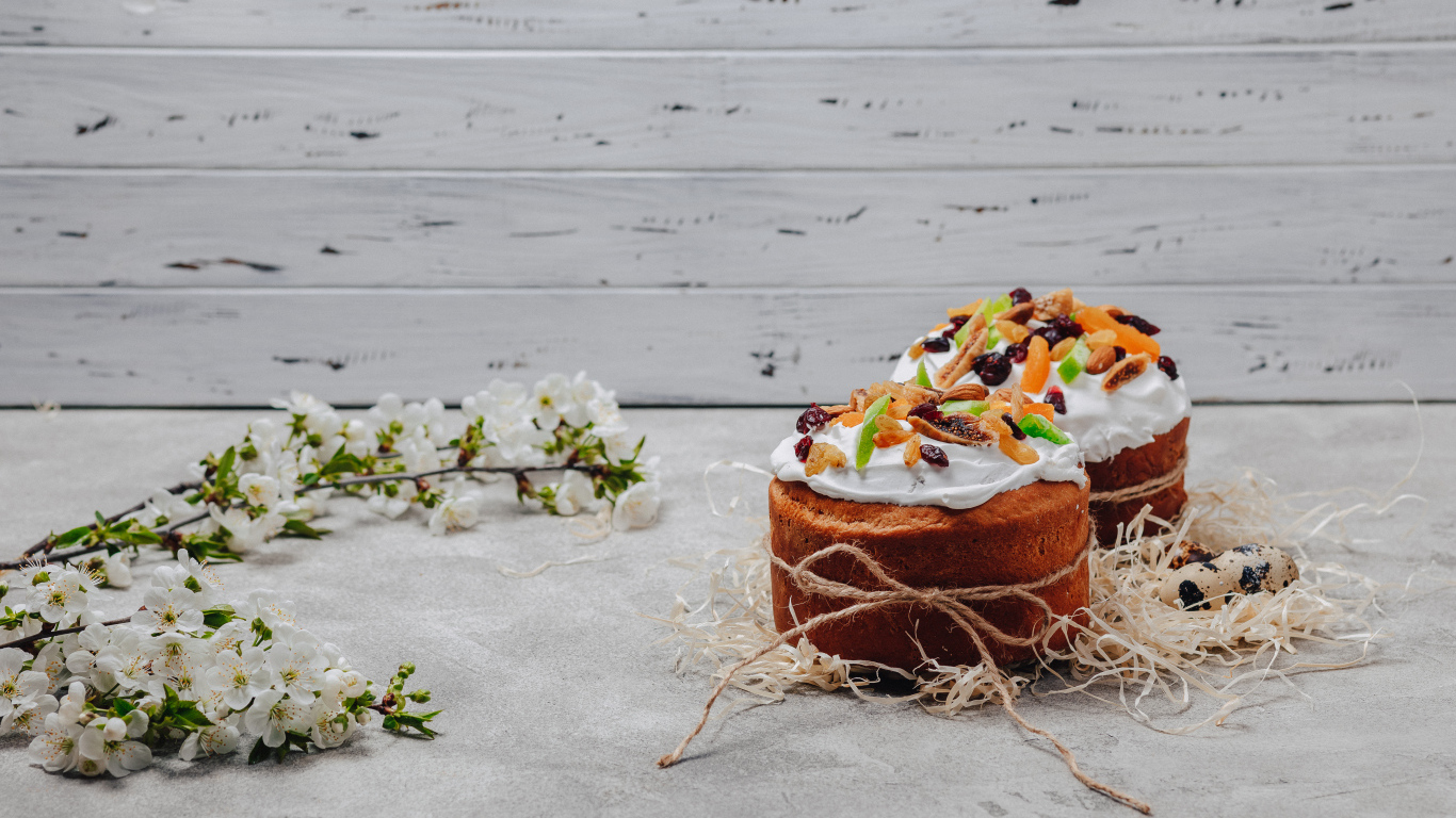 Красивые пасхальные куличи с веткой вишни на сером столе на Пасху