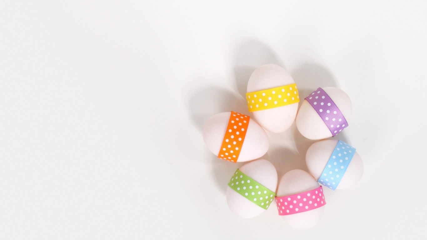 Белые яйца с ленточками на белом фоне