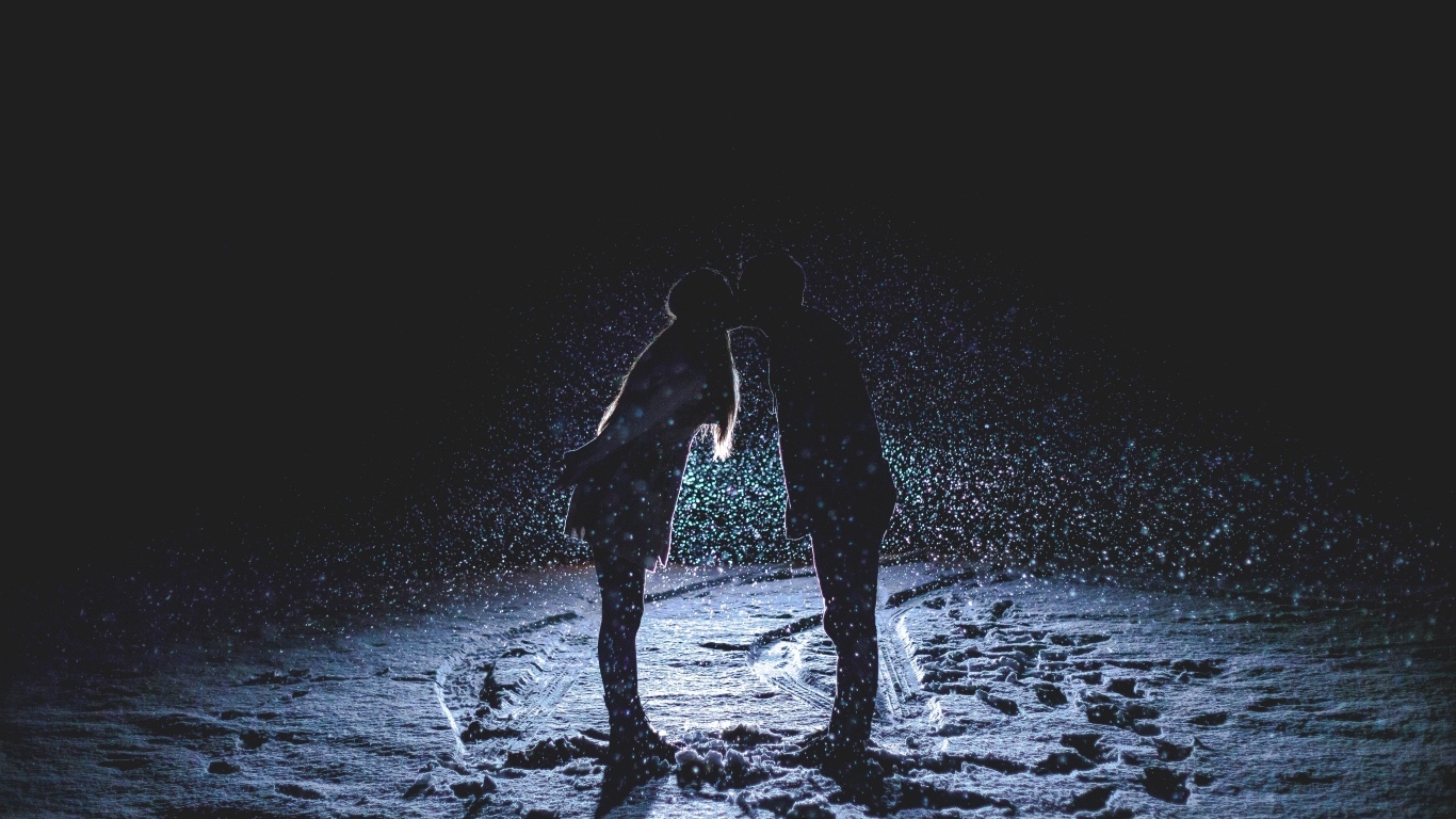 Поцелуй влюбленной пары на снегу ночью