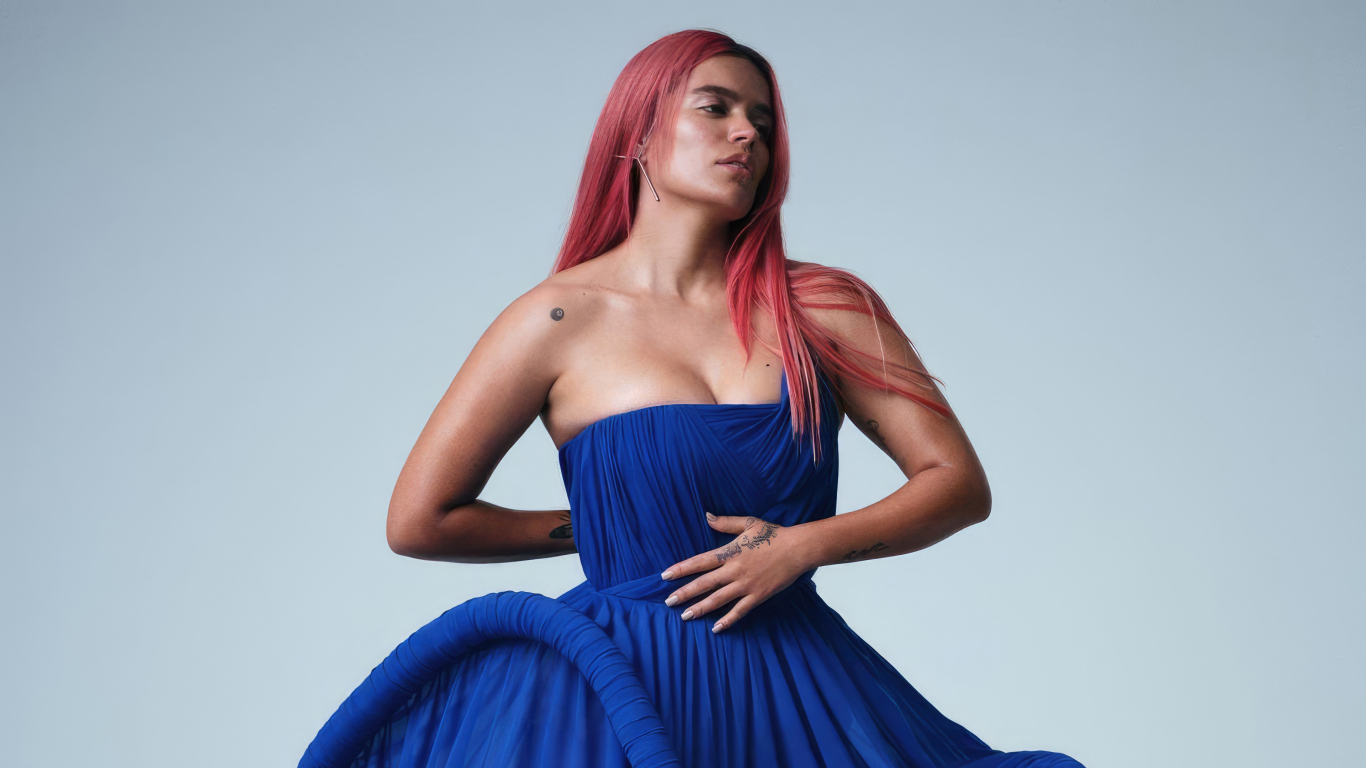 Певица Karol G в синем платье на сером фоне