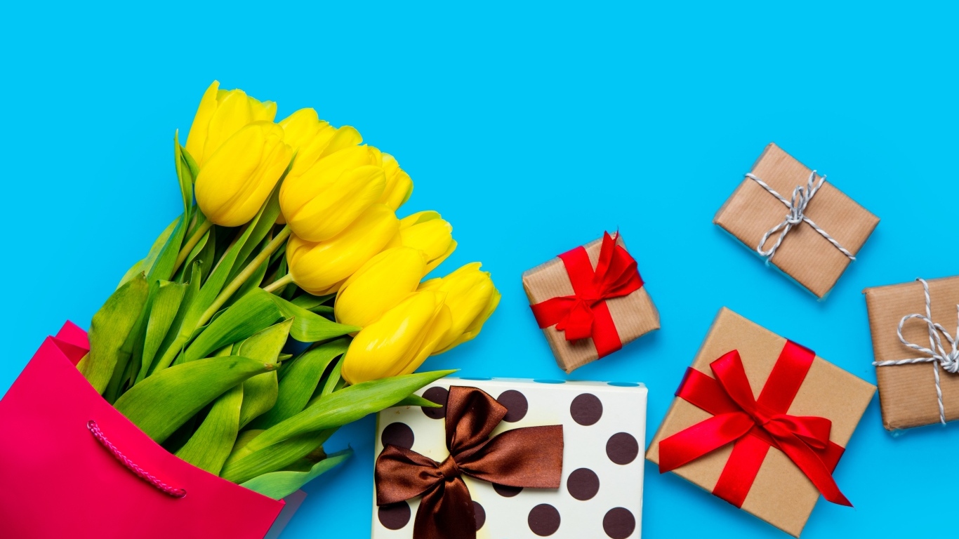 Букет желтых тюльпанов с подарками на голубом фоне