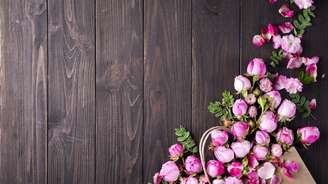 Бутоны розовой розы на деревянном столе