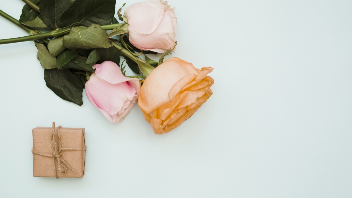 Три розы и подарок на сером фоне