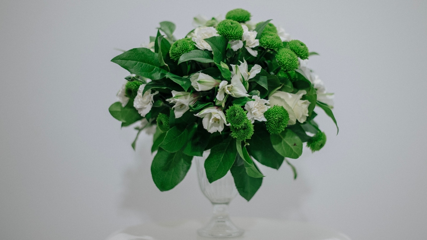 Белый букет с зелеными листьями на сером фоне