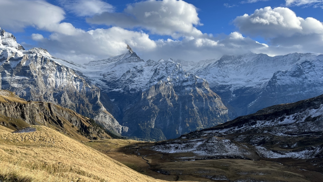 Высокие покрытые снегом горы в белых облаках