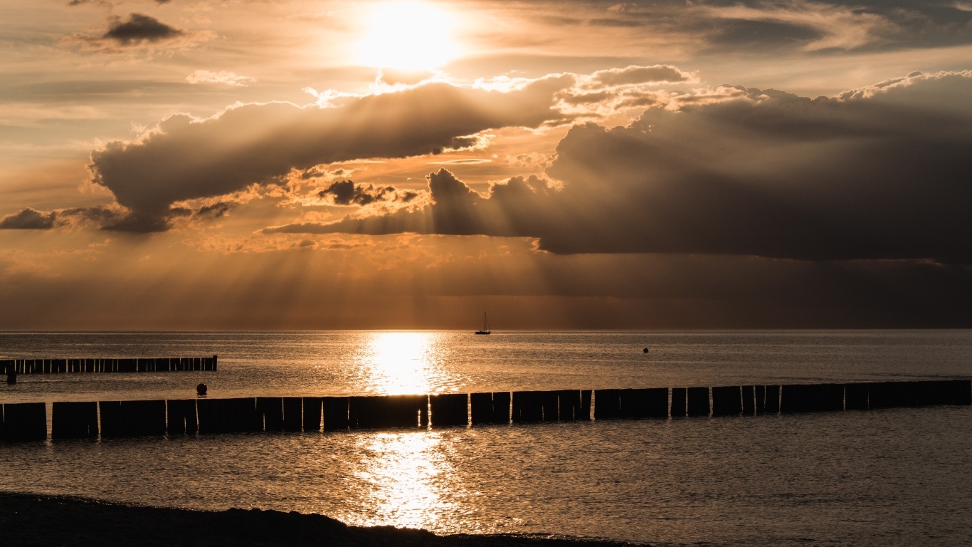 Яркое солнце за облаками над морем