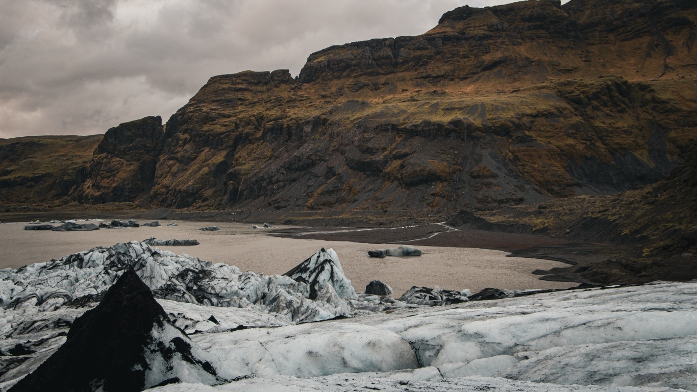 Холодный грязный снег на берегу моря у гор 