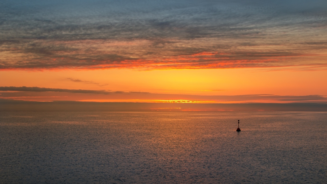 Яркий оранжевый закат на морском горизонте