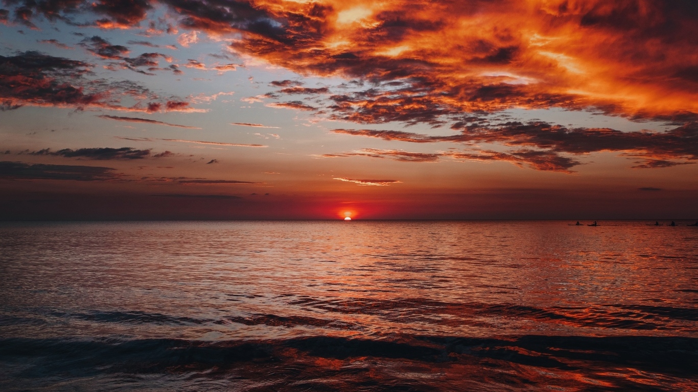 Красные облака в небе над морем на закате