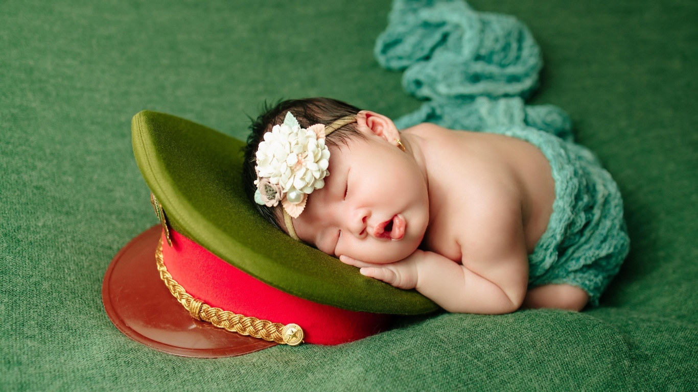 Маленький ребенок спит на военной фуражке