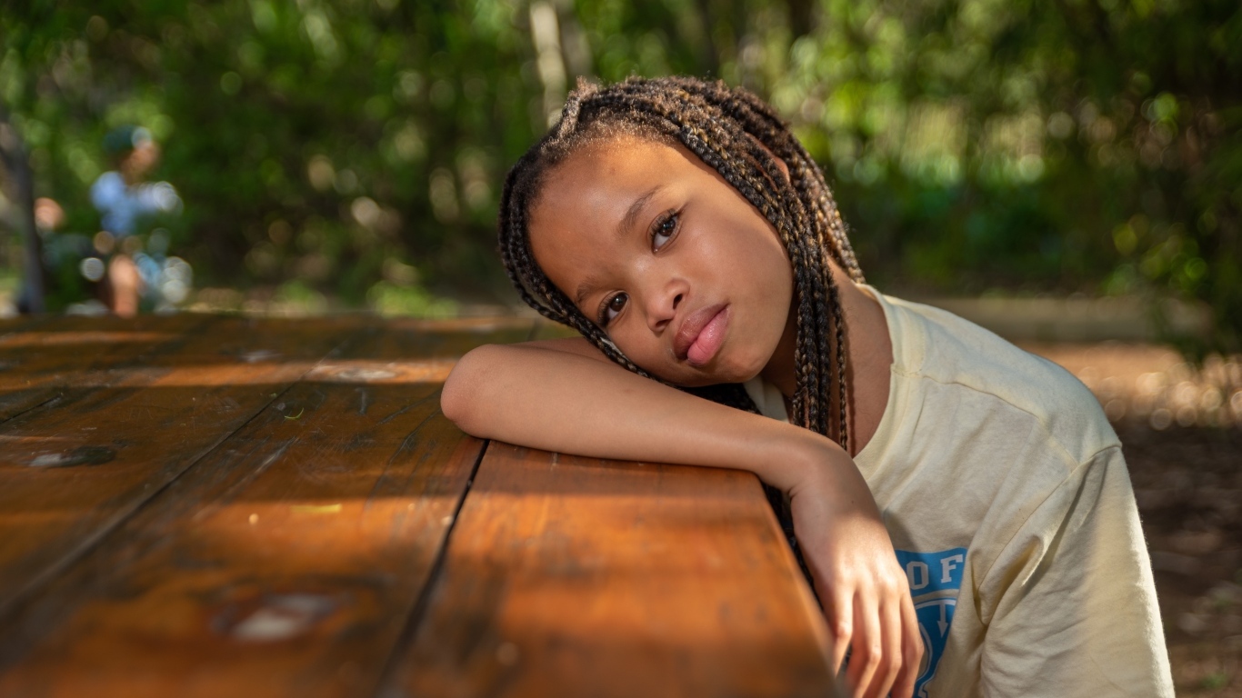 Красивая темнокожая девочка с косичками на голове 