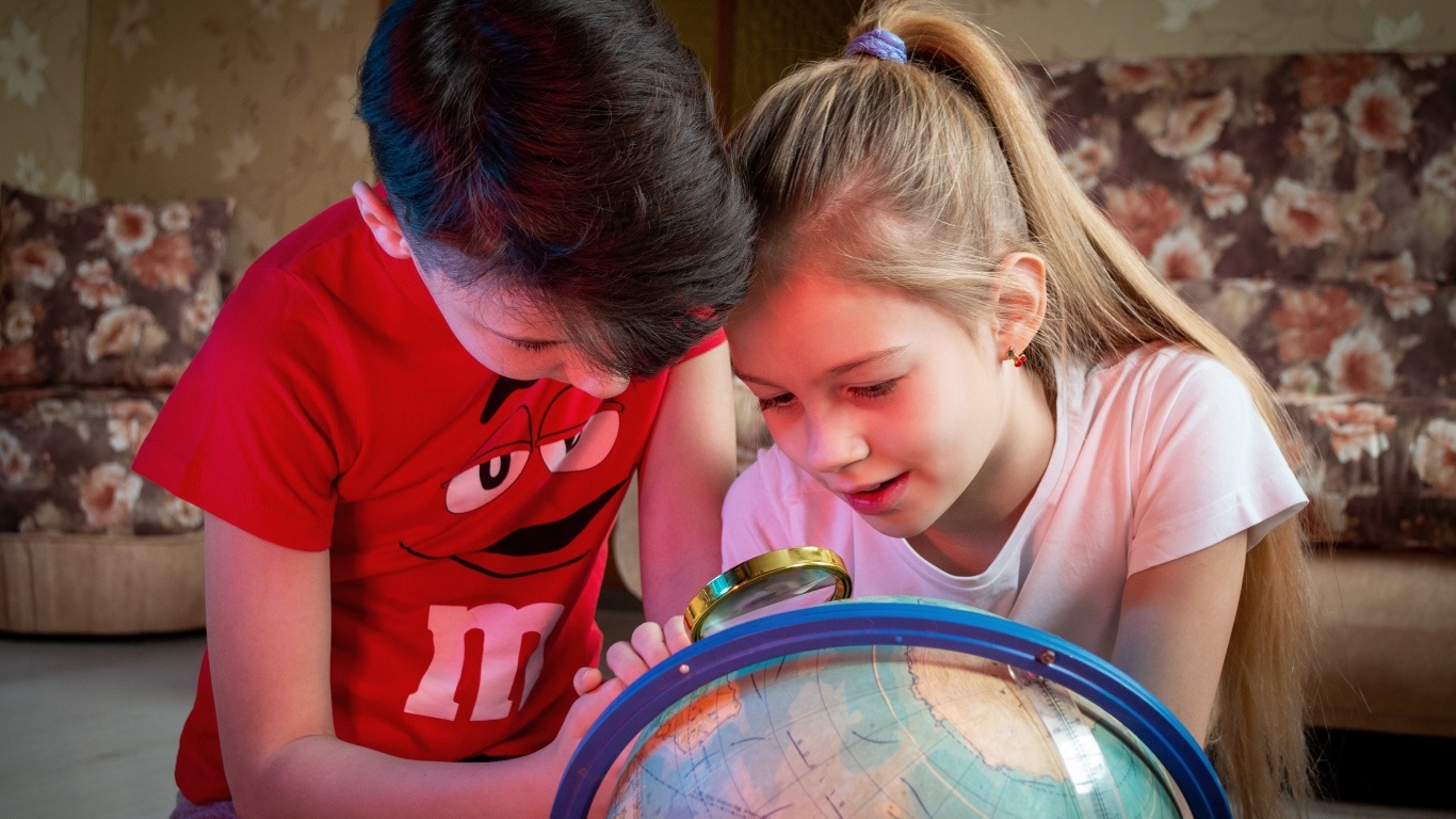 Дети школьники изучают глобус