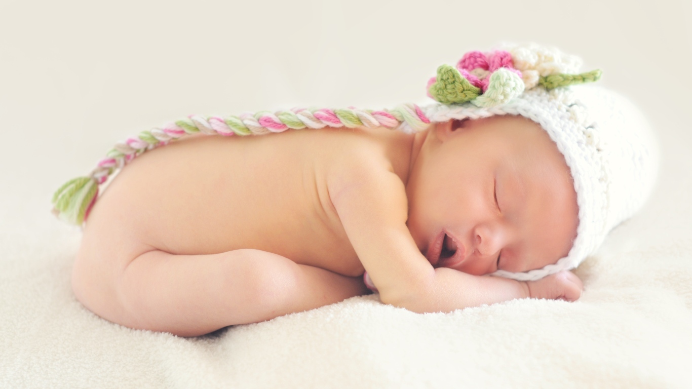 Нежный спящий ребенок в вязаной шапке 