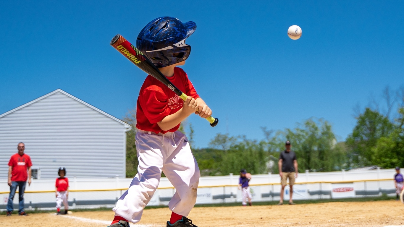 Маленький мальчик играет в бейсбол 