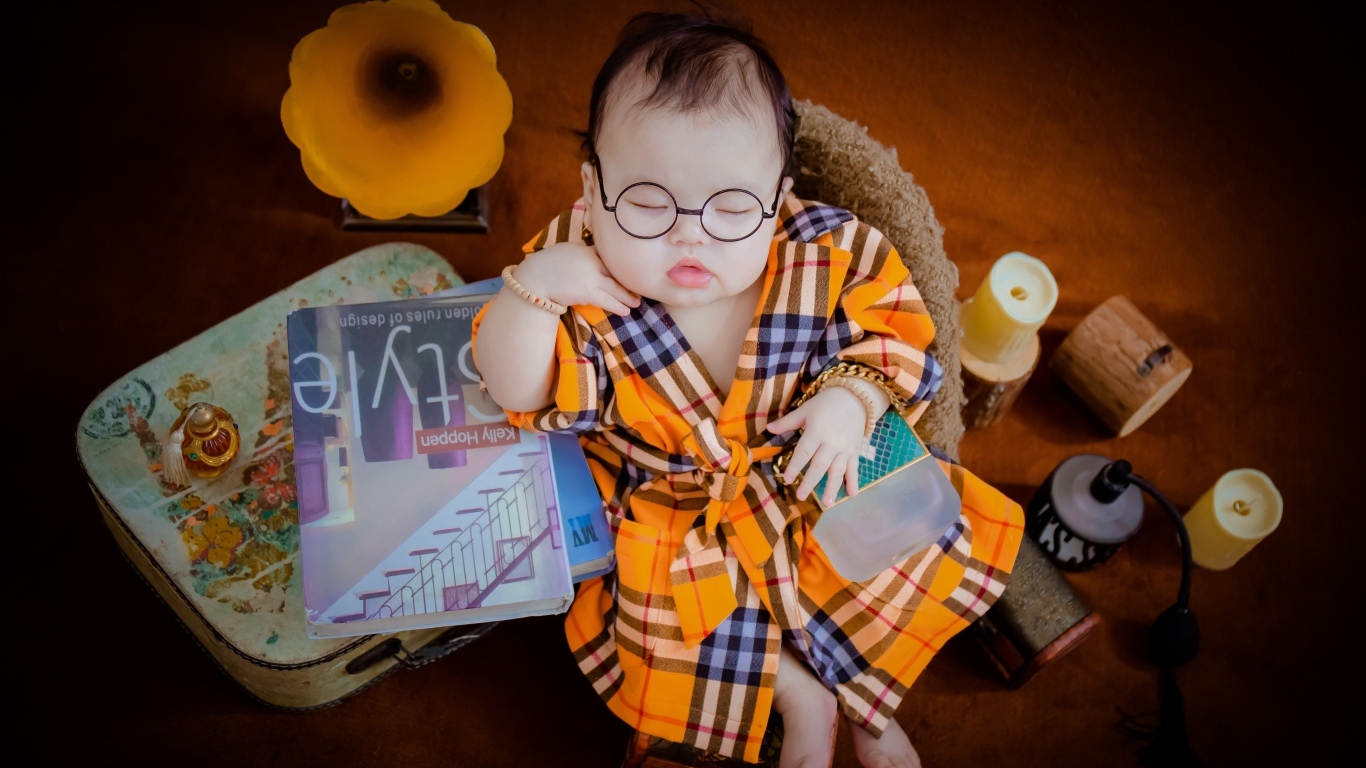 Маленький спящий ребенок в очках и халате