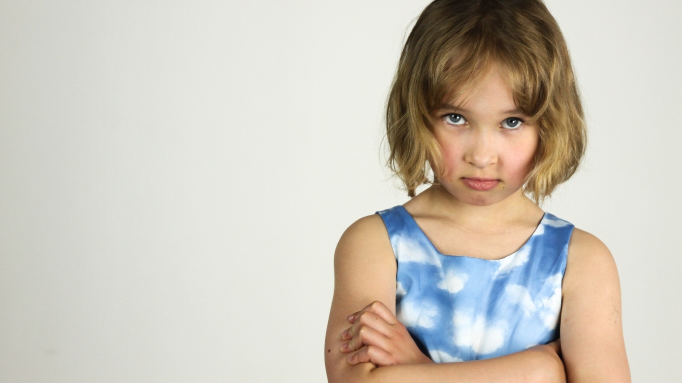 Серьезная девочка на сером фоне