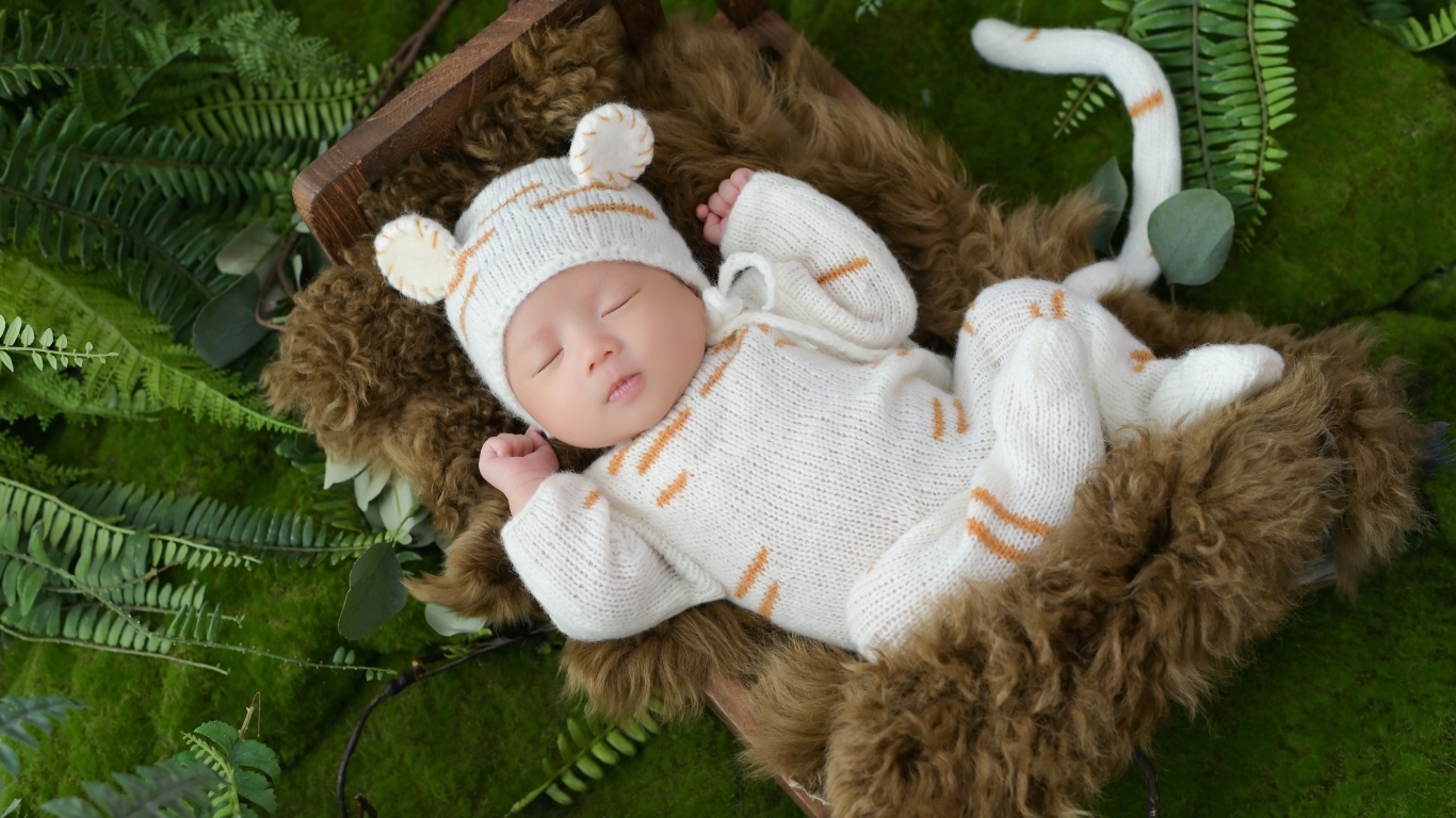 Спящий новорожденный ребенок в костюме тигренка