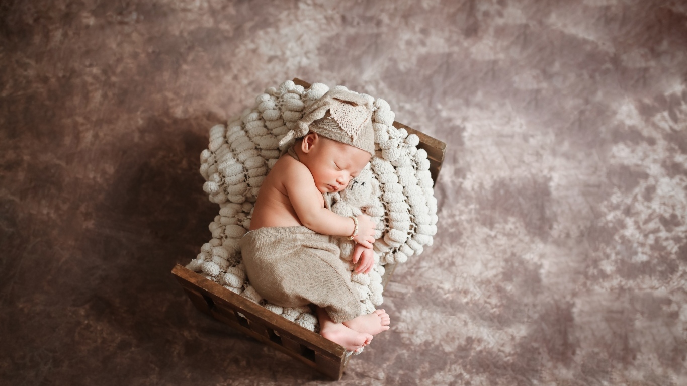 Спящий новорожденный ребенок в кроватке 