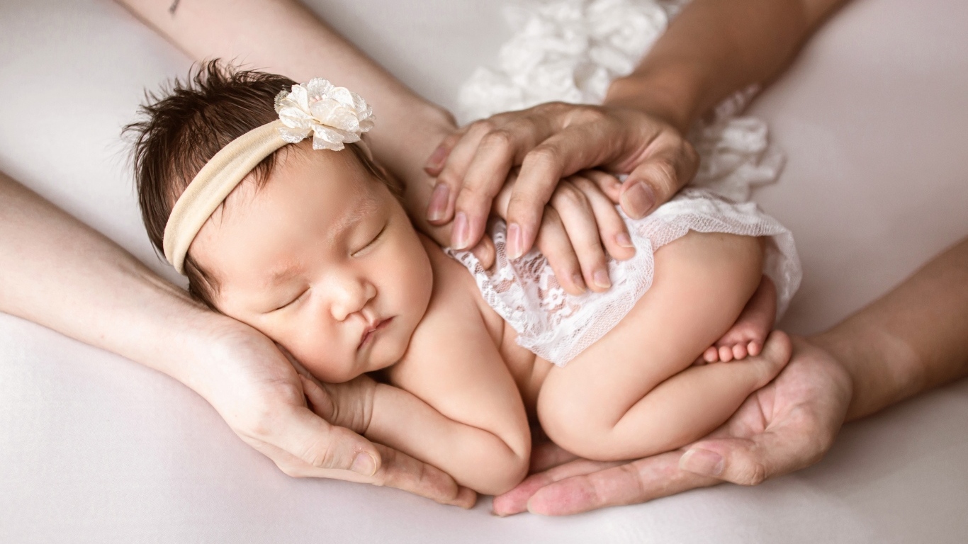 Руки родителей оберегают спящего малыша