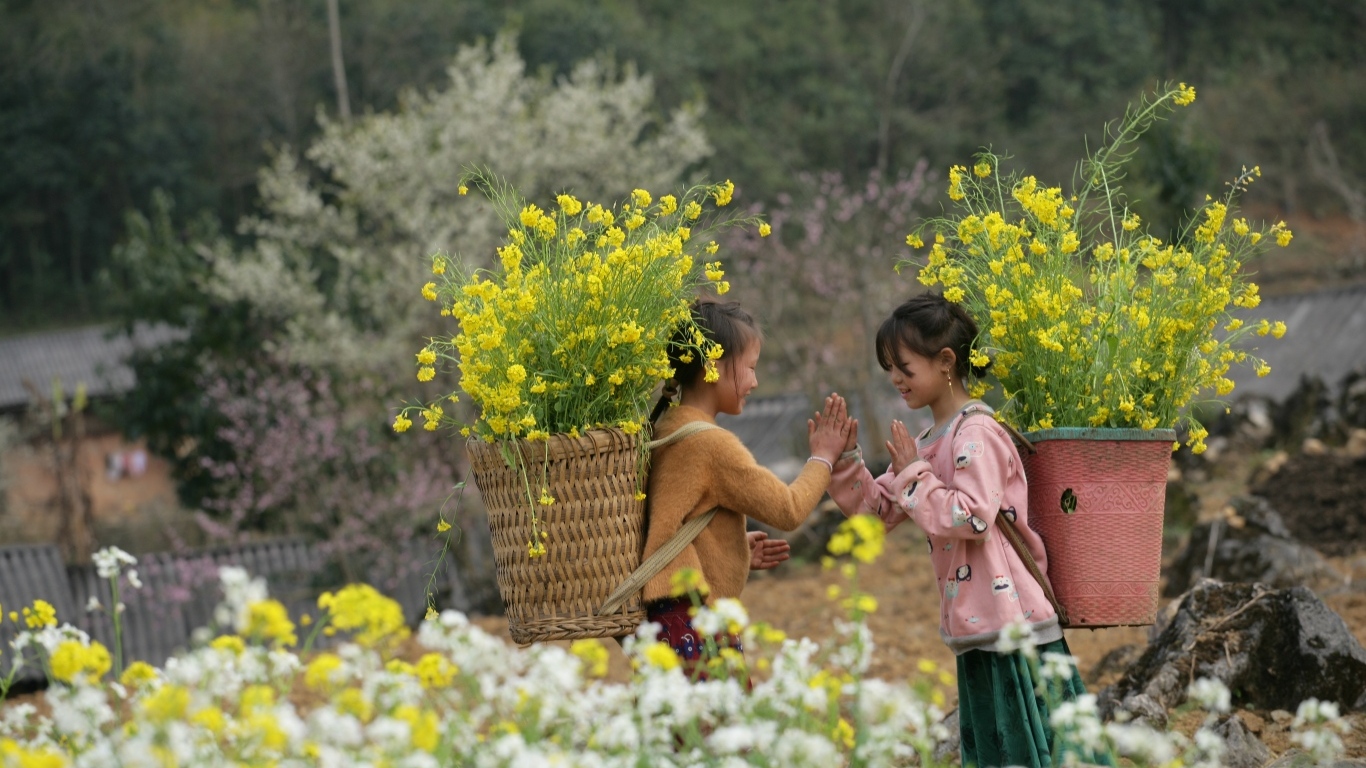 Две маленькие девочки азиатки с корзинами с желтыми цветами