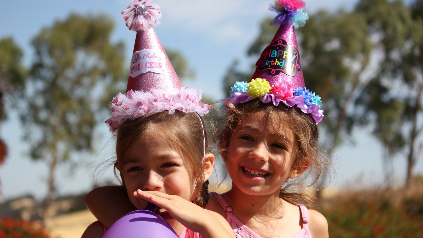Две маленькие веселые девочки отмечают день рождения