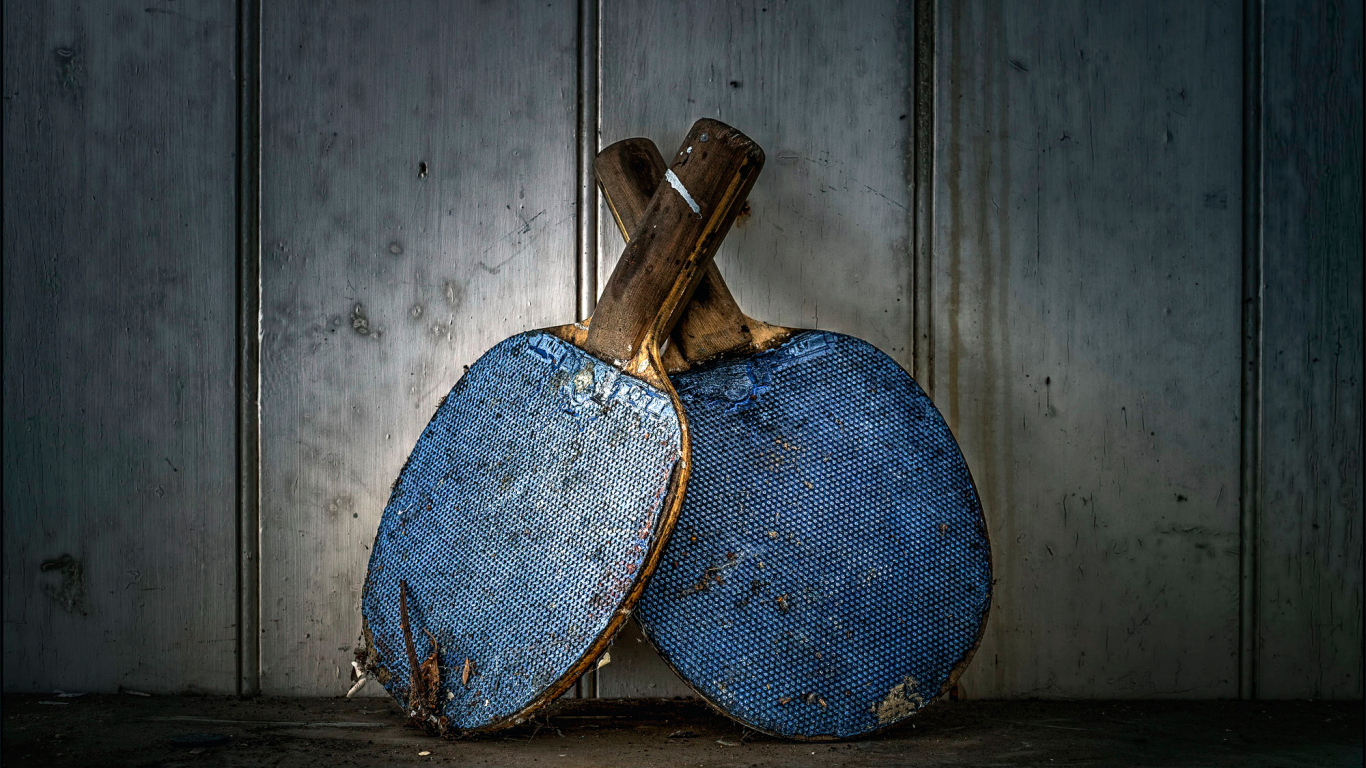 Две старые ракетки для настольного тенниса у стены