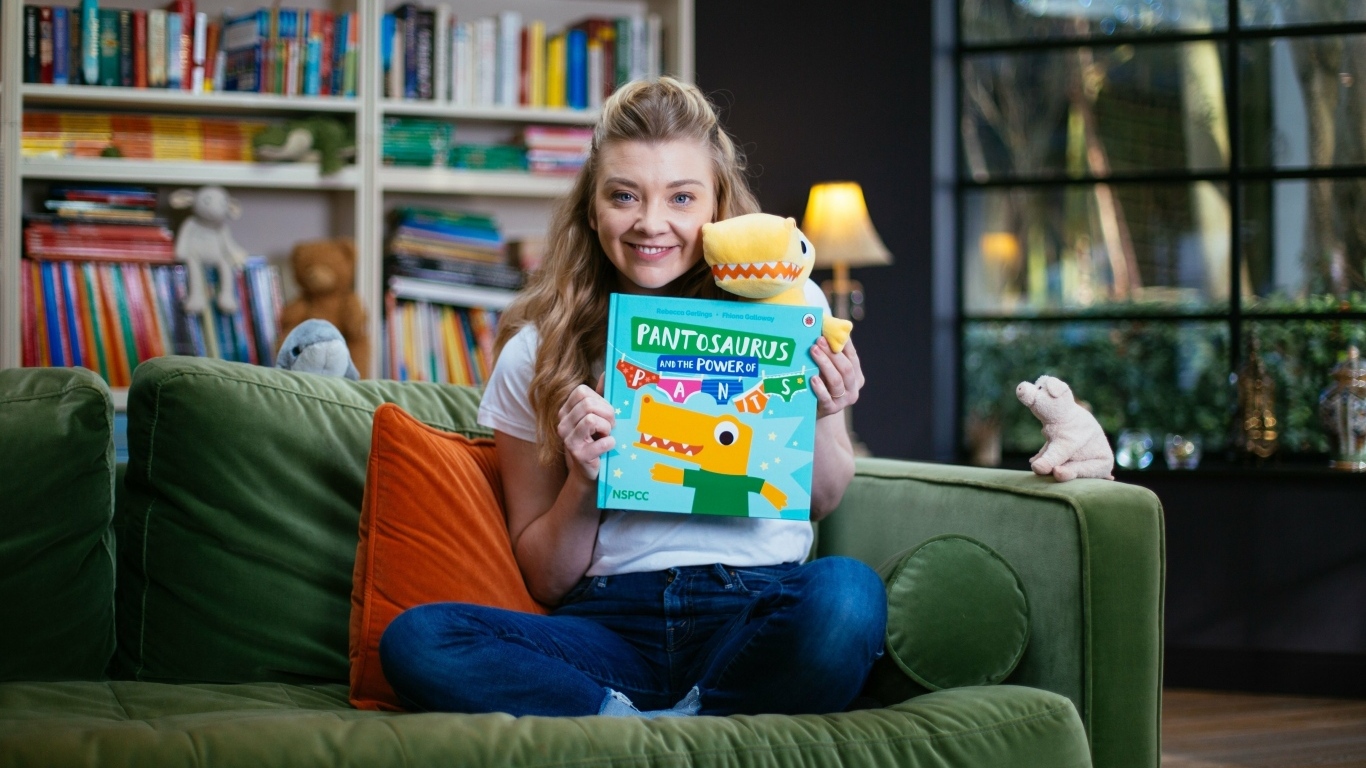 Актриса Натали Дормер  с книгой в руках на диване