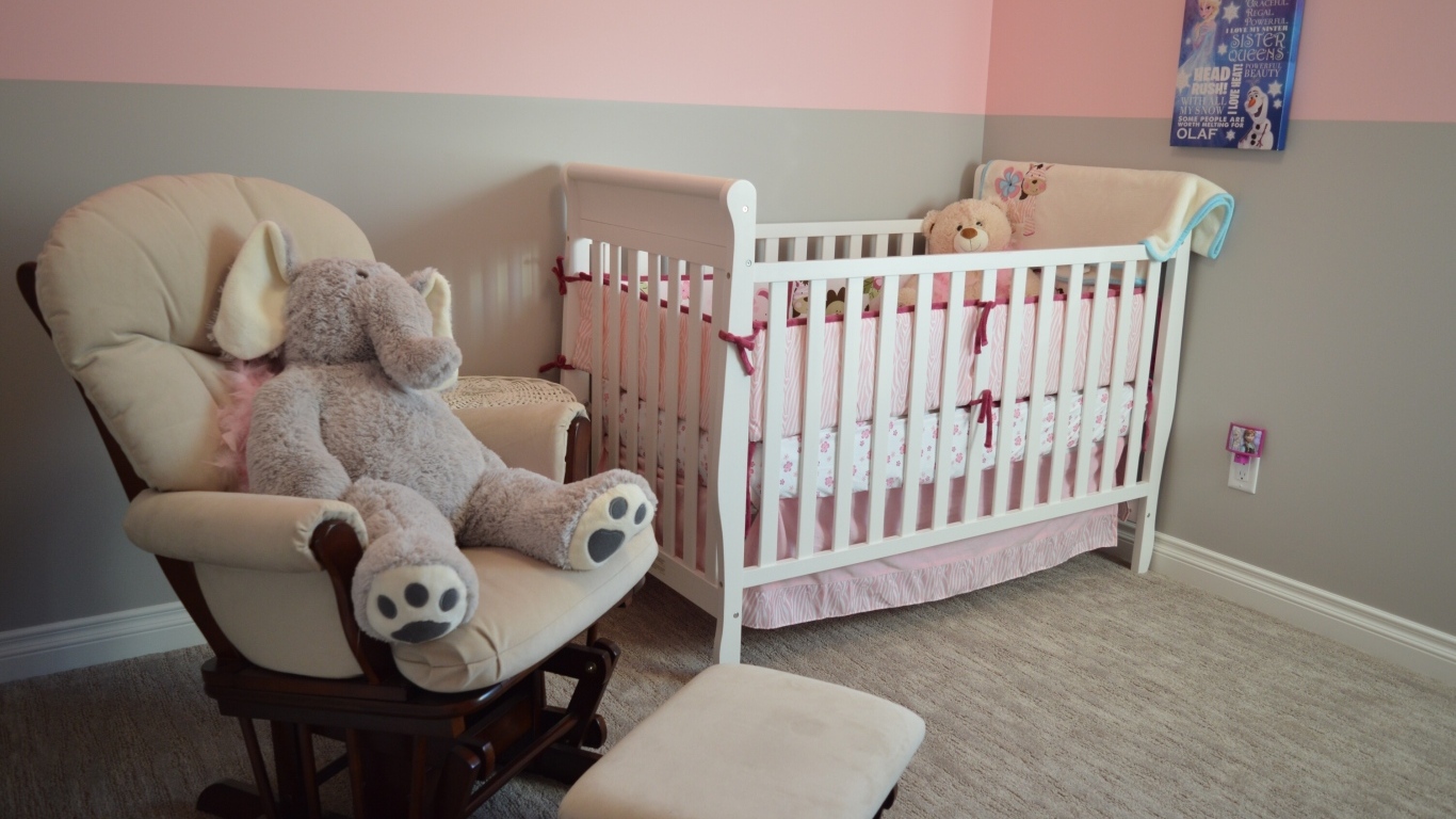 Кровать и кресло с игрушками в детской комнате