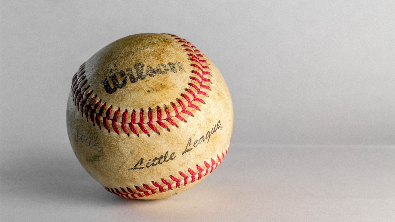 Старый бейсбольный мяч на сером фоне